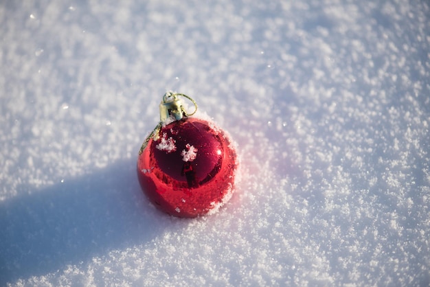 palle rosse di natale con lunghe ombre nella neve fresca in una bella giornata invernale di sole