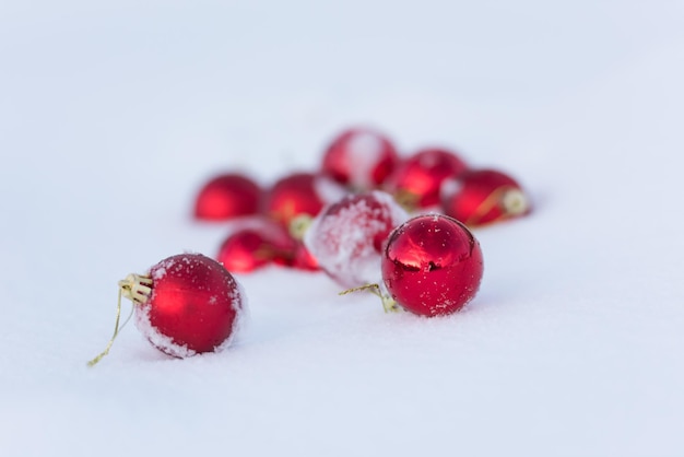 palle rosse di natale con lunghe ombre nella neve fresca in una bella giornata invernale di sole