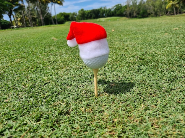 Pallina da golf festiva su maglietta con cappello di babbo natale in cima per le festività natalizie sul campo da golf
