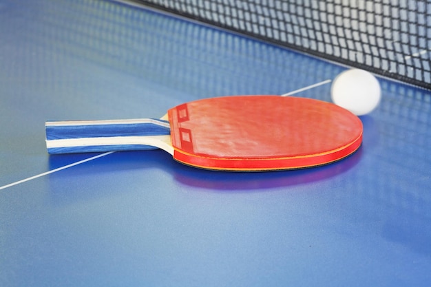 Pallina da paddle tennis rossa sul tavolo da ping pong blu