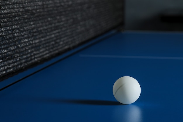 Pallina da ping pong su un tavolo blu