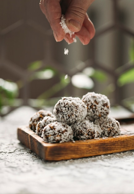 palline di caramelle fatte di datteri e scaglie di cocco