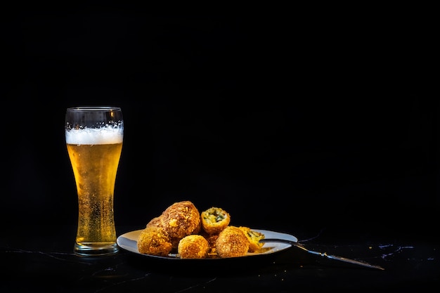 Palline di formaggio con aglio e aneto all'interno per uno spuntino con un bicchiere di birra