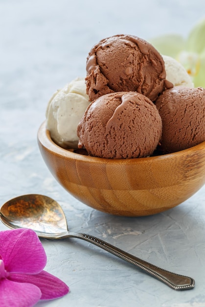 Palline di gelato alla vaniglia e cioccolato in una ciotola di legno