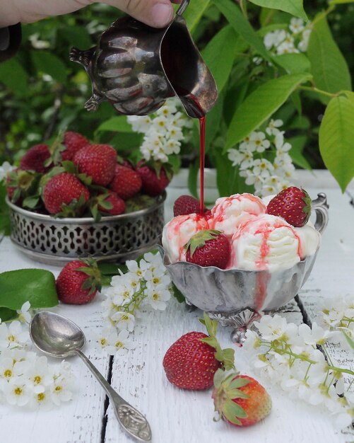 Palline di gelato con sciroppo di fragole e bacche di fragola