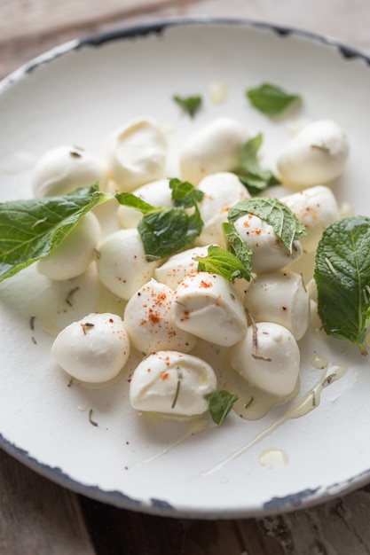 Palline di mozzarella in zolla con la menta. Concetto di cibo tradizionale italiano. Vista dall'alto