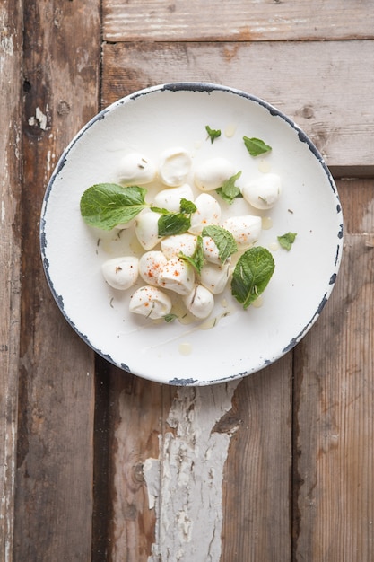 Palline di mozzarella in zolla con la menta. Concetto di cibo tradizionale italiano. Vista dall'alto