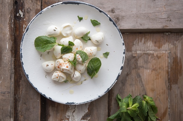 Palline di mozzarella in zolla con la menta. Concetto di cibo tradizionale italiano. Vista dall'alto