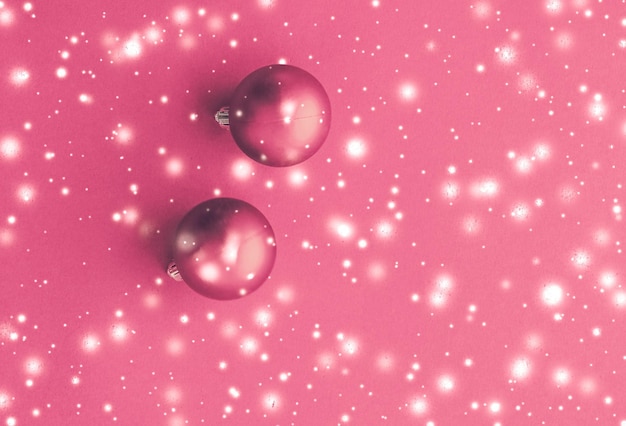 Palline di Natale su sfondo rosa con neve glitter carta vacanza invernale di lusso