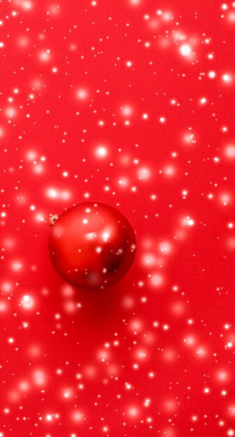 Palline di Natale su sfondo rosso con neve glitter carta vacanza invernale di lusso