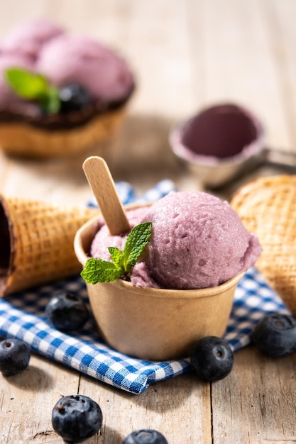 Palline per gelato al mirtillo con cialda sul tavolo di legno