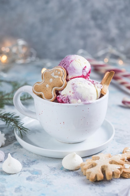 Palline per gelato con bastoncini di zucchero in tazza e decorazioni natalizie. I dolci di Capodanno