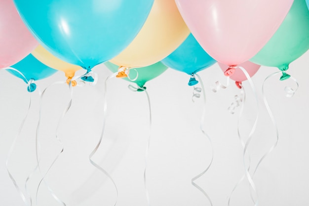Palloncini colorati con nastri su sfondo grigio