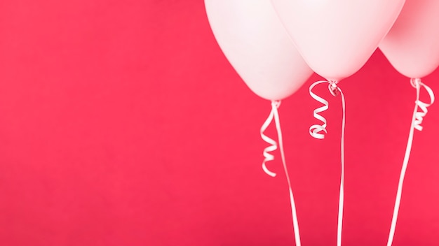 Palloncini rosa su sfondo rosso con spazio di copia