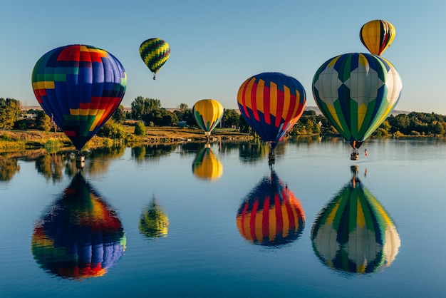 Palloncino ad aria calda multicolore che vola sopra l'acqua