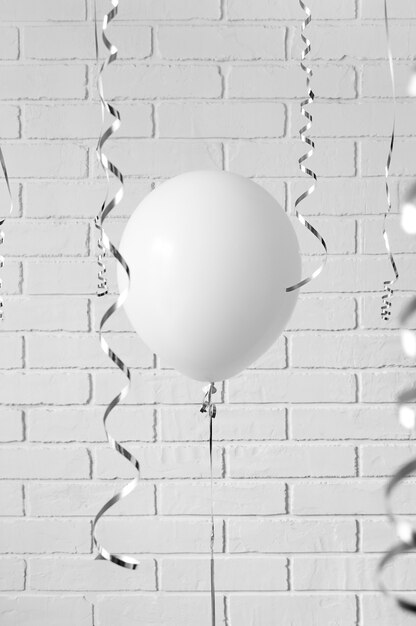 Palloncino bianco contro un muro di mattoni grigi. concetto