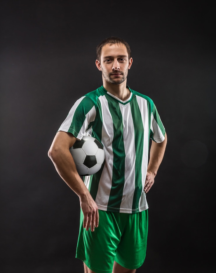 Foto pallone da calcio che gira fiducioso giocatore di football sulla superficie nera