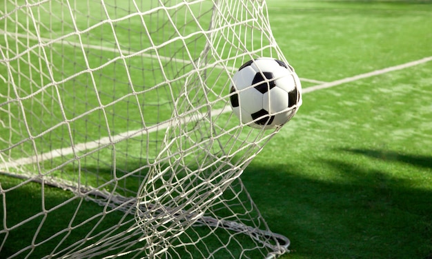 Pallone da calcio nella rete di un obiettivo. Concetto di calcio