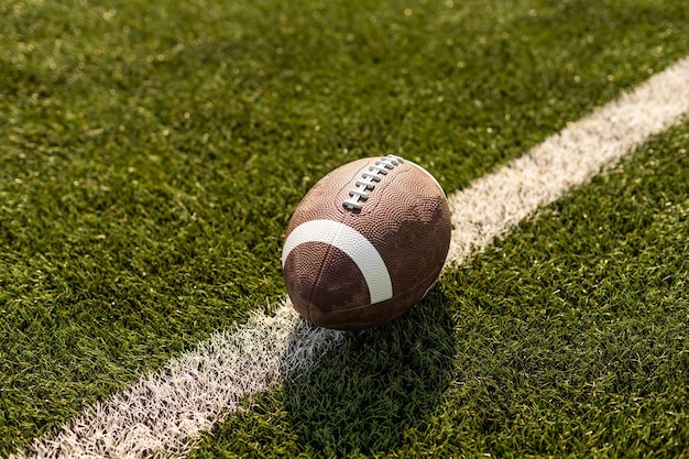 Pallone da rugby americano sull'erba nello stadio.