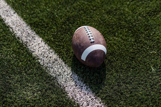 Pallone da rugby americano sull'erba nello stadio.