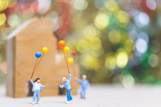 Pallone felice della tenuta della famiglia sul parco con il fondo variopinto del bokeh