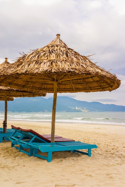 Palm shelter e lettini presso la China Beach di Da Nang, Vietnam. Si chiama anche Spiaggia di Non Nuoc. Sullo sfondo il Mar Cinese Meridionale.