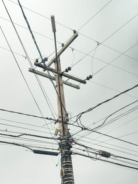 Palo con fili elettrici palo di illuminazione e fili elettrici di supporto in una piccola città del fuoco selettivo del Brasile