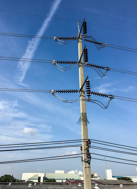 Palo elettrico concreto sotto il cielo blu.