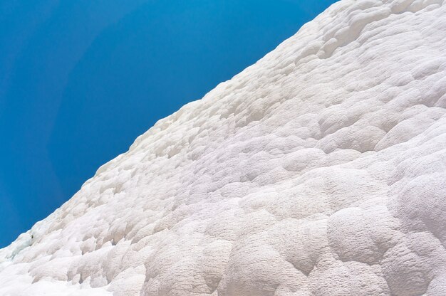 Pamukkale, castello di cotone, meraviglia naturale è creata da strati di travertino bianco che sembrano cotone, Turchia. Muro di pamukkale naturale contro un cielo blu