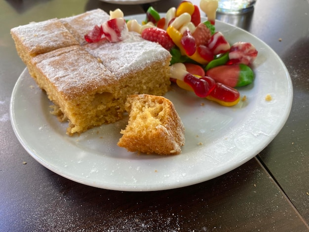 Pan di Spagna e caramelle sul piatto bianco per dessert dopo pranzo per la famiglia.