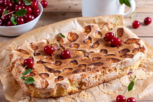 Pan di Spagna o torta chiffon con ciliegie così morbide e deliziose con ingredienti su tavola di legno Concetto di panetteria fatto in casa per sfondo e carta da parati