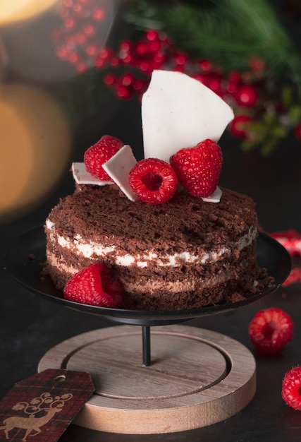 pan di spagna tre cioccolatini in una decorazione di festa di Capodanno con lamponi. su sfondo scuro