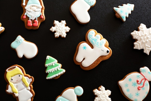 Pan di zenzero del regalo di natale su oscurità, biscotti del pan di zenzero di natale con lo zucchero a velo, vista superiore