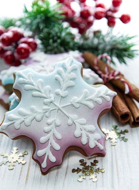 Pan di zenzero di Natale con le decorazioni di Natale sulla tavola di legno bianca. Sfondo delle vacanze di Natale