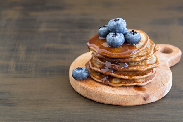 Pancake al cioccolato con mirtilli su uno sfondo scuro.