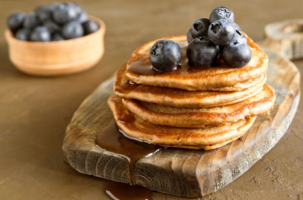 Pancake al cioccolato con mirtilli su uno sfondo scuro.