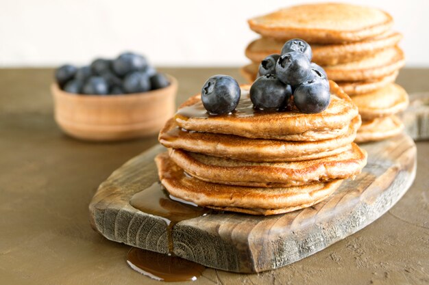 Pancake al cioccolato con mirtilli su uno sfondo scuro.