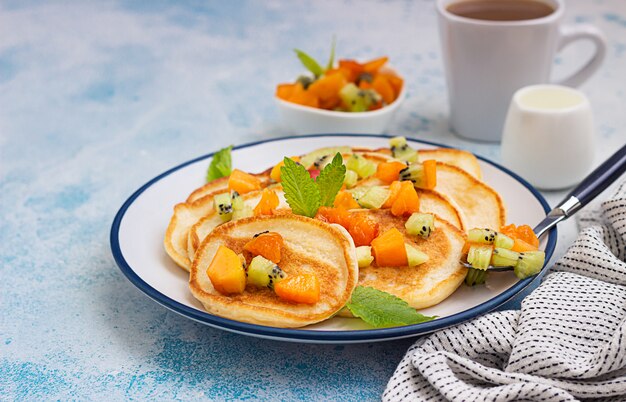 Pancake americani classici fatti in casa con macedonia di frutta a base di albicocca e kiwi