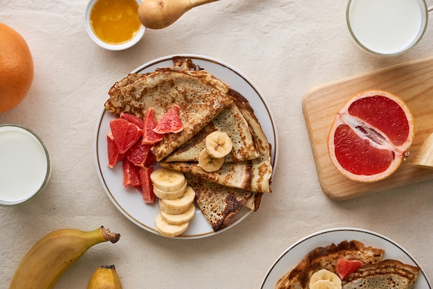 Pancake con banana e pompelmo su uno sfondo chiaro