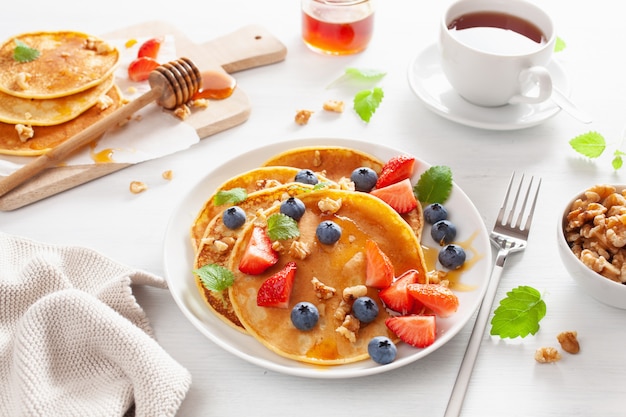 Pancake con miele di fragole ai mirtilli e noci per la colazione