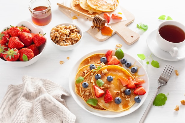 Pancake con miele di fragole ai mirtilli e noci per la colazione