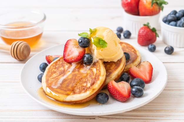 pancake con mirtilli, fragole, miele e gelato alla vaniglia