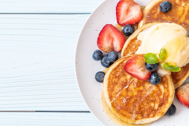 pancake con mirtilli, fragole, miele e gelato alla vaniglia