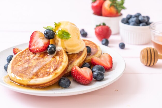 pancake con mirtilli, fragole, miele e gelato alla vaniglia