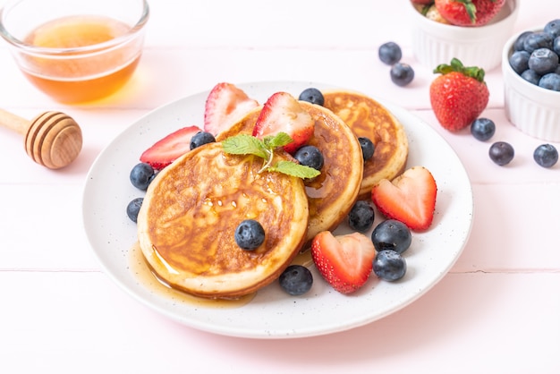 pancake con mirtilli freschi, fragole fresche e miele