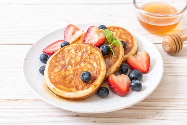 pancake con mirtilli freschi, fragole fresche e miele