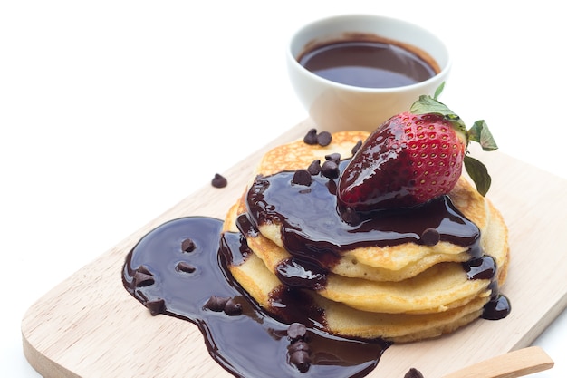 Pancake con sciroppo di cioccolato e fragole su sfondo bianco