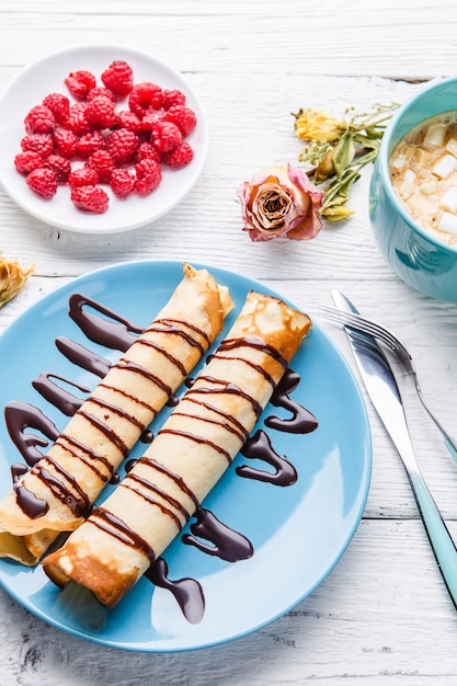 Pancake fatti in casa o blini russi con salsa di cioccolato sul piatto