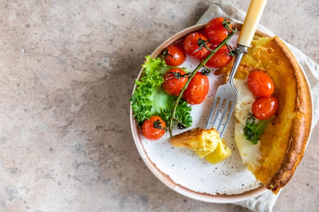 Pancake olandese salato con pomodori arrosto, mozzarella e foglie di insalata Cucina danese