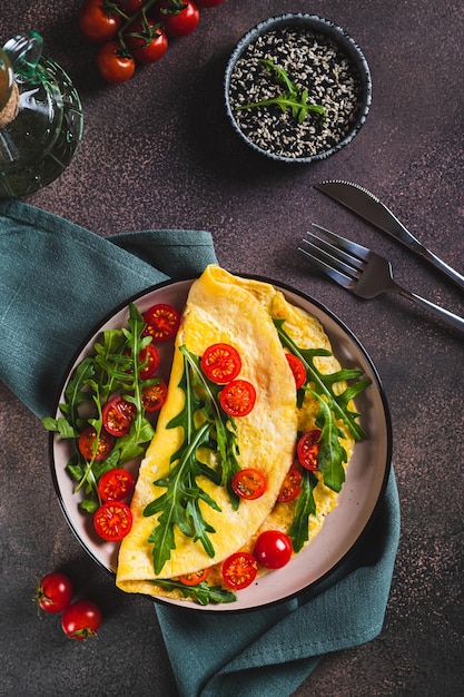 pancake omelette con pomodori ciliegino e arugula su un piatto sul tavolo e vista verticale